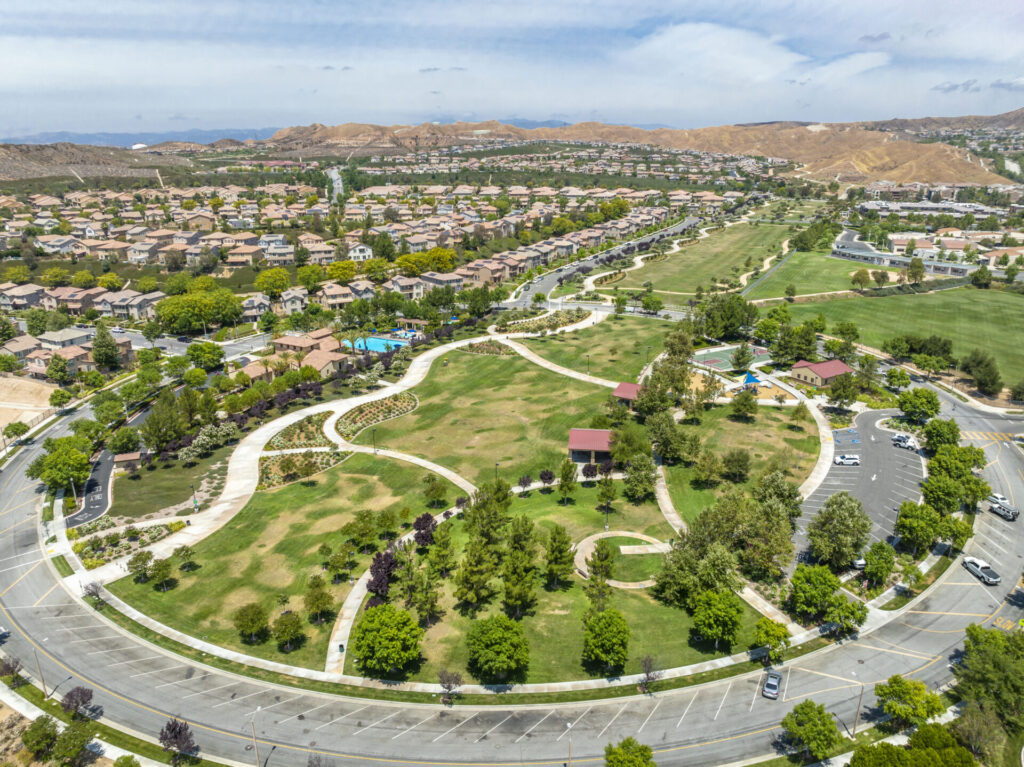 Aerial view of a lush community park surrounded by homes and scenic hills in Santa Clarita Valley.