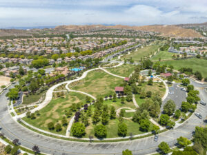Aerial view of a lush community park surrounded by homes and scenic hills in Santa Clarita Valley.
