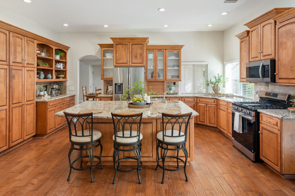 The large kitchen of 24416 Firenze Pl and the lovely warm wood cabinetry and stainless steel appliances. 