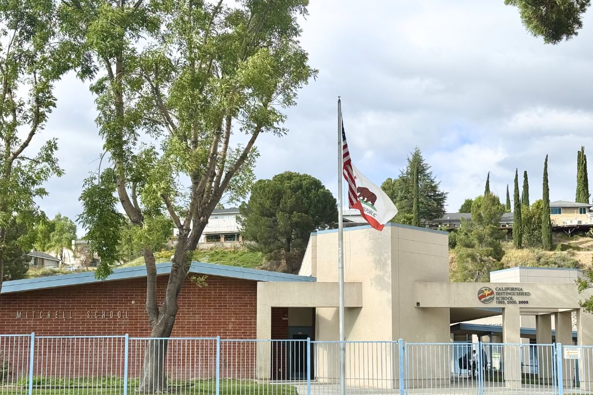 Looking at the front of Mitchell Community Elementary School with the flags blowing in the wind